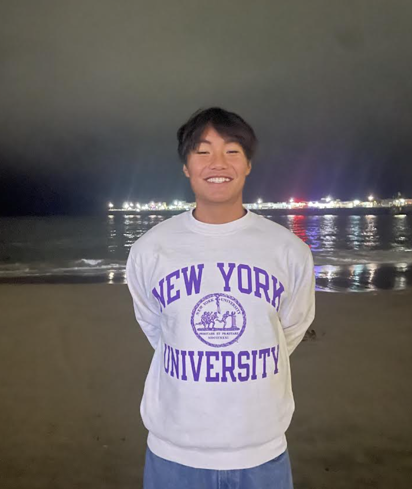 Senior Isaac Shang poses in a New York University sweatshirt after announcing his commitment to swimming for the Division 3 school this August.